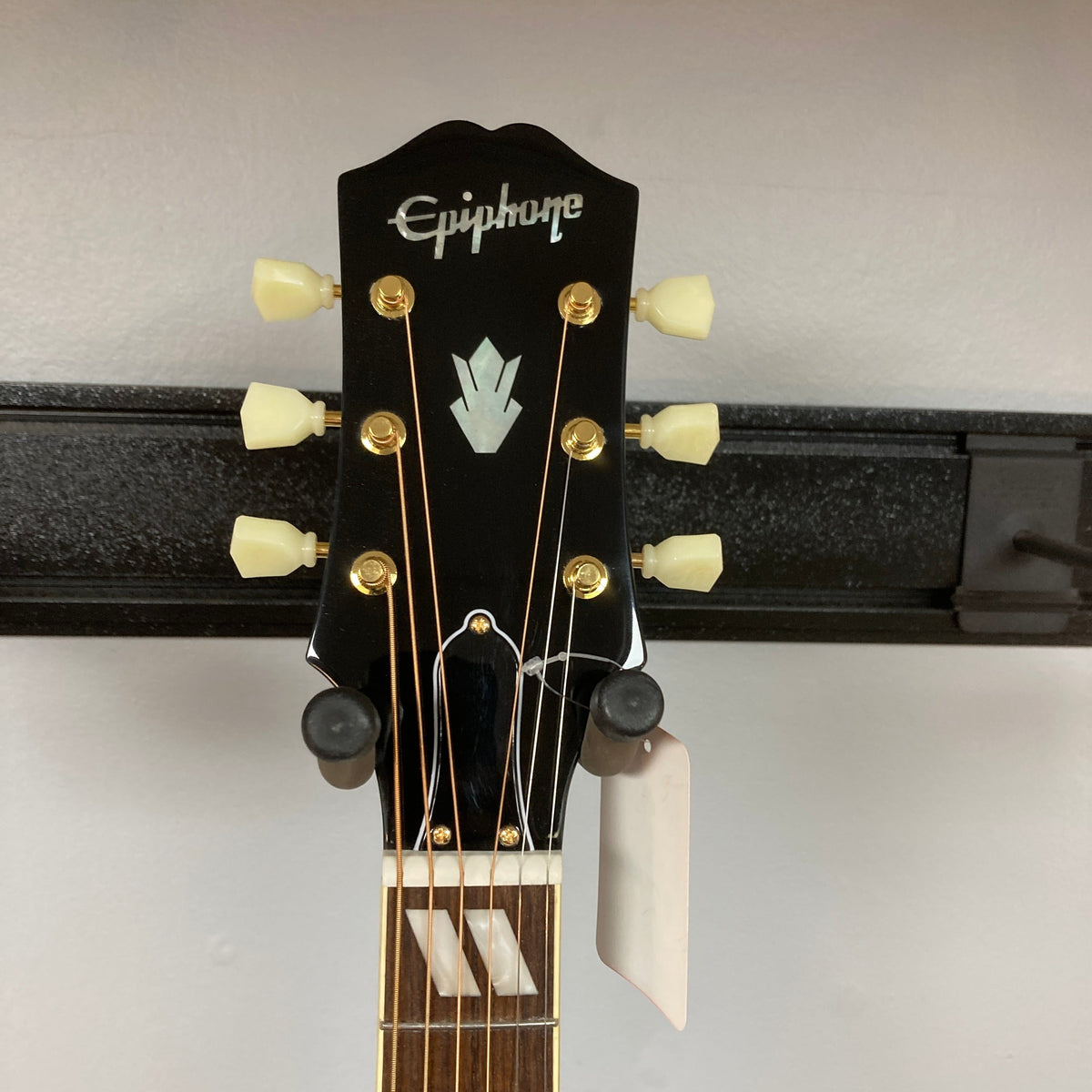 Epiphone Miranda Lambert Bluebird Studio - Bluebonnet guitar mounted on a wall, showcasing its intricate design and signature features.