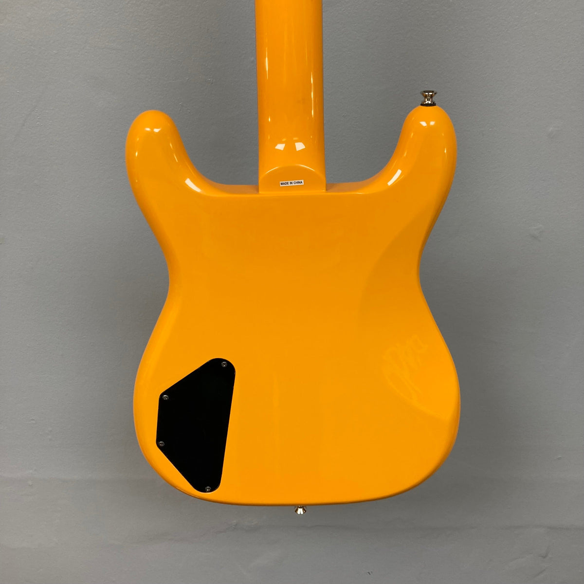 Epiphone Newport Bass California Coral, featuring a unique body shape, mahogany construction, and modern controls, displayed on a wall.