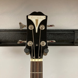 Epiphone Newport Bass Cherry on a stand, showcasing its vintage body shape and detailed neck with visible humbuckers and control knobs.