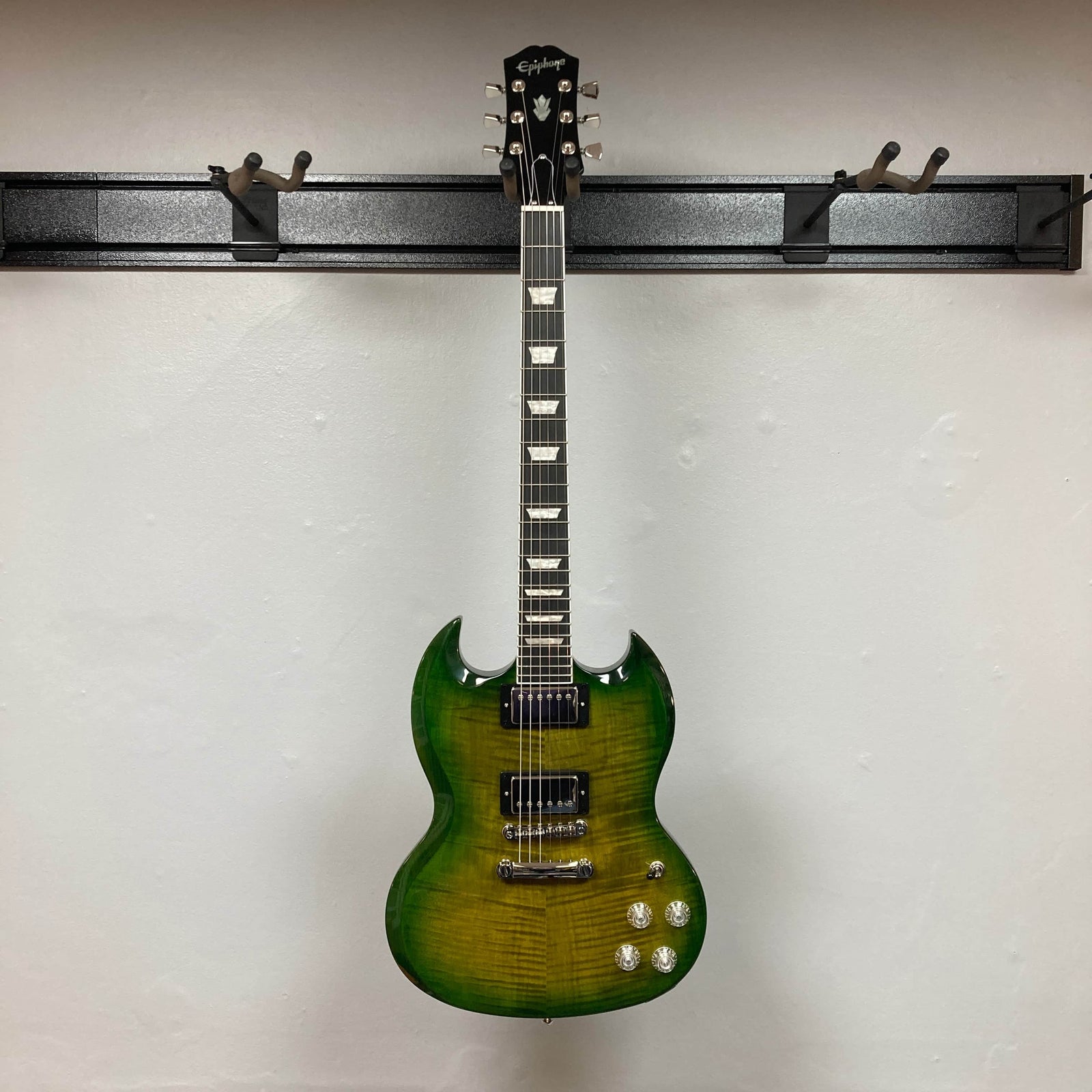 The Epiphone SG Modern Figured in Iguana Burst features a glossy finish, ProBucker humbuckers, four control knobs, a SlimTaper neck, and a double cutaway body—shown on a plain white background. Includes gig bag.