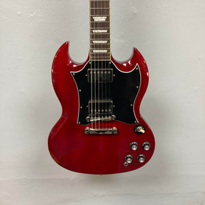 The Epiphone SG Standard Cherry w/Gigbag features a mahogany body, black pickguard, chrome hardware, four control knobs, and dual humbucker pickups, shown here against a plain white wall.