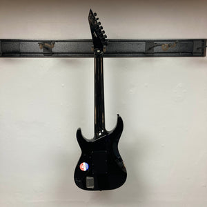 An ESP E-II Horizon FR-7 Black w/Case 7-string electric guitar by ESP hangs on a wall-mounted rack, displaying its back, a sticker near the bottom, and the distinctive Floyd Rose bridge.