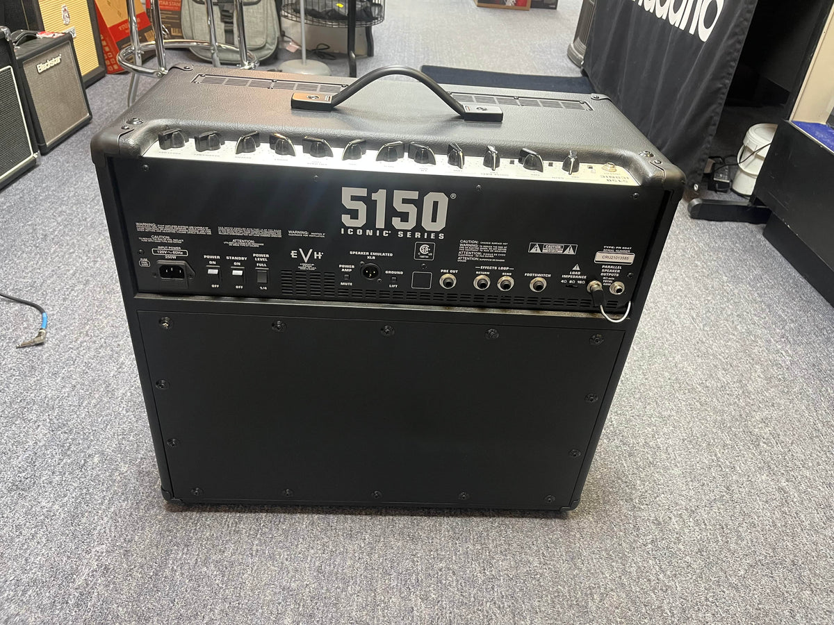 The EVH 5150® Iconic® Series 6L6 40W 1x12 Combo used/consign tube amplifier by EVH is shown from the back in a showroom, displaying its ports, control knobs, carry handle on top, and resting on a carpeted floor.