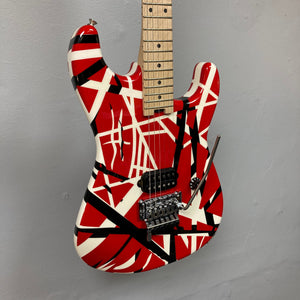 EVH Striped Series guitar with red, black, and white stripes, featuring a close-up of strings, highlighting its unique design.