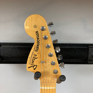 Close-up of a 1997 Fender Artist Series Jimi Hendrix Tribute Stratocaster guitar neck and pickguard with protective plastic.