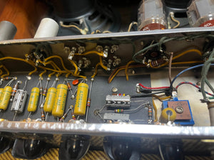 Close-up of the internal electronic components and wiring inside a 1957 Fender Bassman 5F6 Narrow Panel 40-Watt 4x10" Guitar Combo w/Flight Case, highlighting vintage capacitors, resistors, and vacuum tubes from Fender.