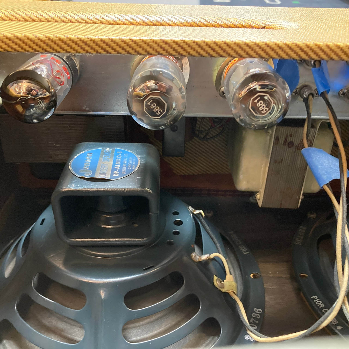 Close-up view of the interior of a 1957 Fender Bassman 5F6 Narrow Panel 40-Watt 4x10" Guitar Combo w/Flight Case, showing vacuum tubes, speaker, transformer, and wiring components. Brand: Fender.
