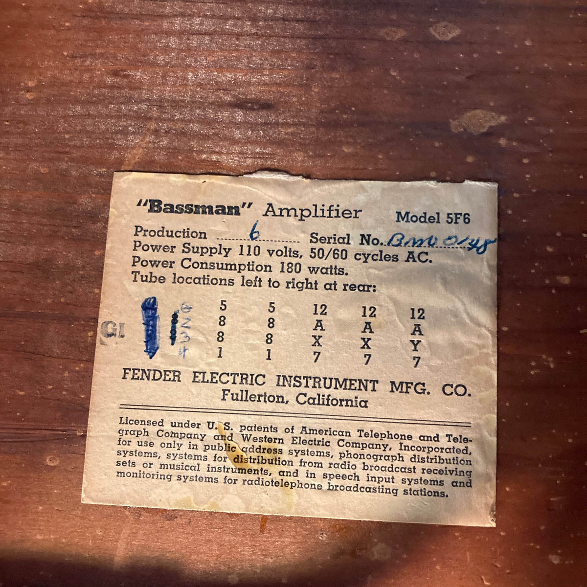 1957 Fender Bassman 5F6 Narrow Panel 40-Watt 4x10" Guitar Combo by Fender, featuring a rectangular label with serial number, warranty info, and tube layout chart on wood; handwritten marks add character.