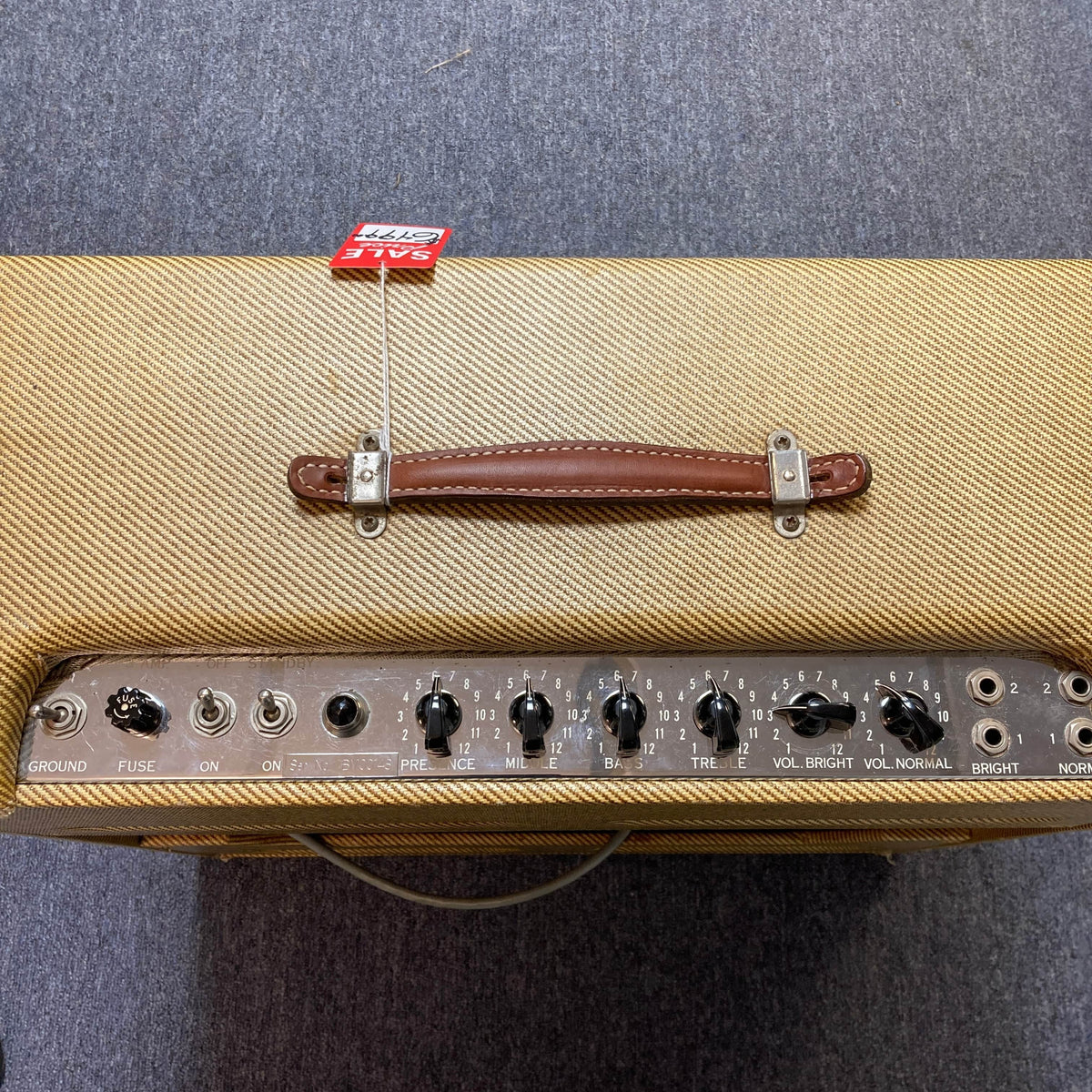 Top view of a 1957 Fender Bassman 5F6 Narrow Panel 40-Watt 4x10" Guitar Combo with brown handle, control knobs, switches, and a red “SOLD” tag on gray carpet. Includes flight case.