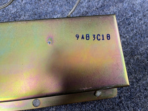 A metal surface marked "9AB3C1B" in blue, two wires above, recalls the core of a 1966 Fender Black Panel Twin Reverb 2-Channel 85-Watt 2x12" Guitar Combo Amp w/Case by Fender, set on a textured gray background.