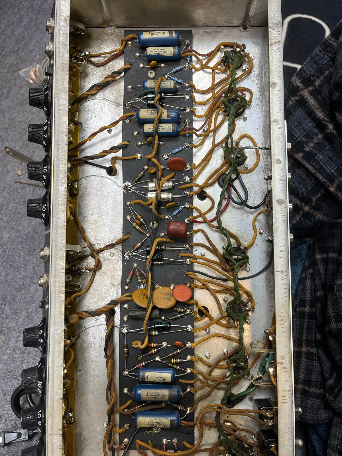 Interior view of a 1966 Fender Black Panel Twin Reverb 2-Channel 85-Watt 2x12" Guitar Combo Amp by Fender, revealing internal wiring, capacitors, resistors, and the classic spring reverb circuitry mounted inside its metal chassis.