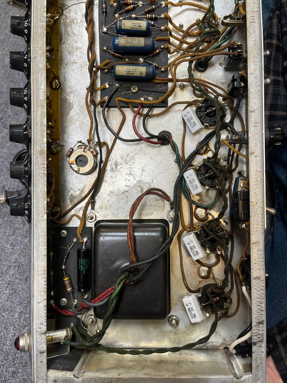 Interior view of a 1966 Fender Black Panel Twin Reverb 2-Channel 85-Watt 2x12" Guitar Combo Amp shows wires, resistors, capacitors on a metal chassis. Control knobs and spring reverb elements are visible. Comes with case. Brand: Fender.