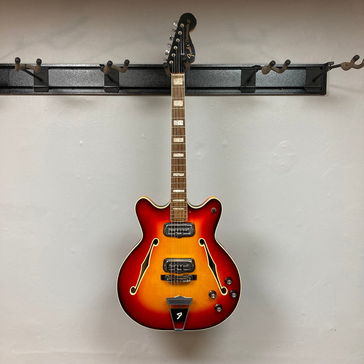 Fender Coronado II 1973 Sunburst on display, showcasing its semi-hollow body and dual Fideli&#39;Tron humbuckers, highlighting craftsmanship and vintage charm.