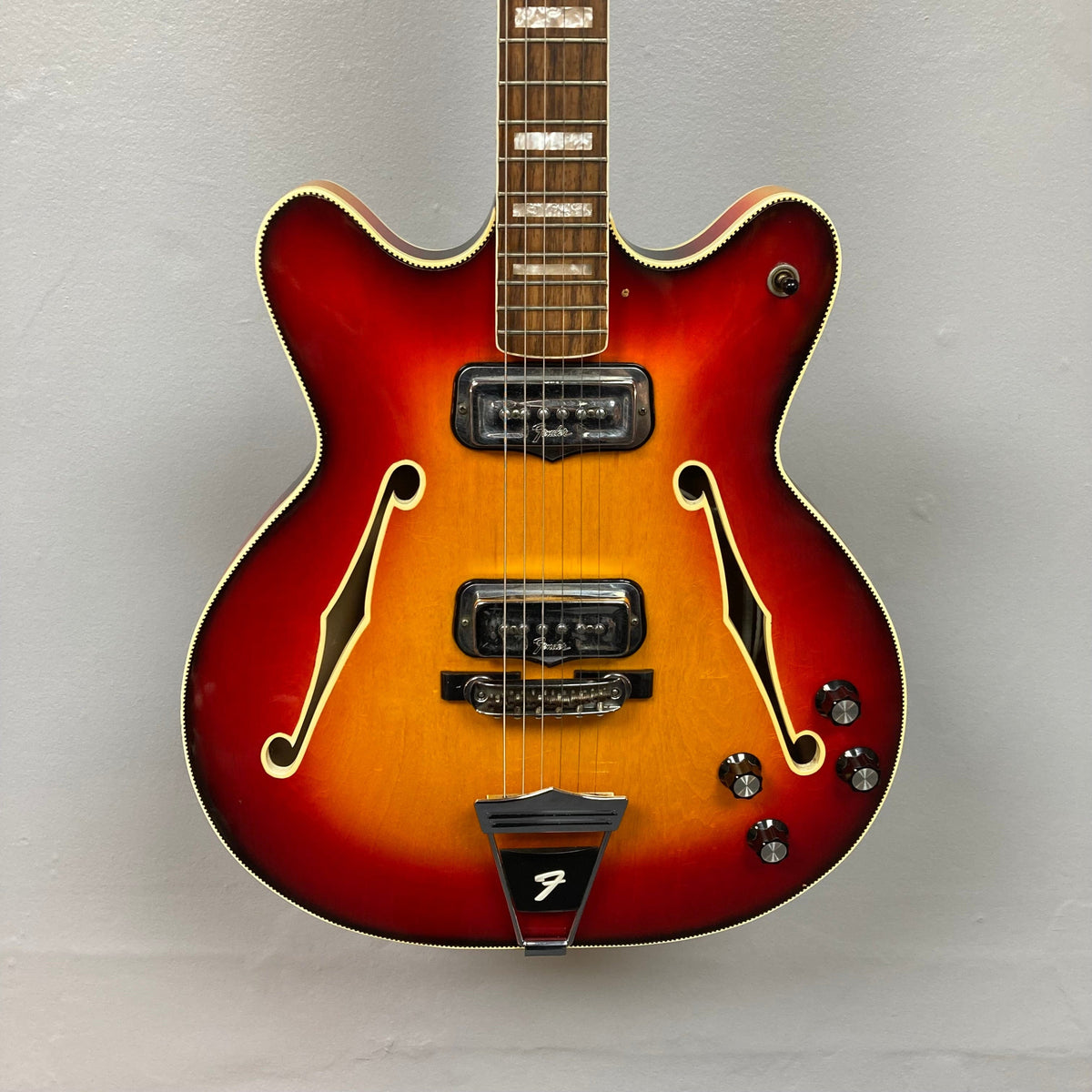 Fender Coronado II 1973 Sunburst: Semi-hollow electric guitar with dual humbuckers, visible strings, and minor finish wear. Comes with a case.