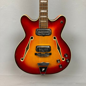 Fender Coronado II 1973 Sunburst: Semi-hollow electric guitar with dual humbuckers, visible strings, and minor finish wear. Comes with a case.