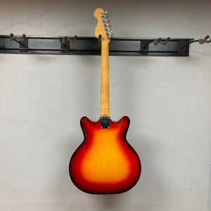 Fender Coronado II 1973 Sunburst guitar on a wall hook, showcasing its semi-hollowbody design and dual Fideli'Tron Humbuckers.