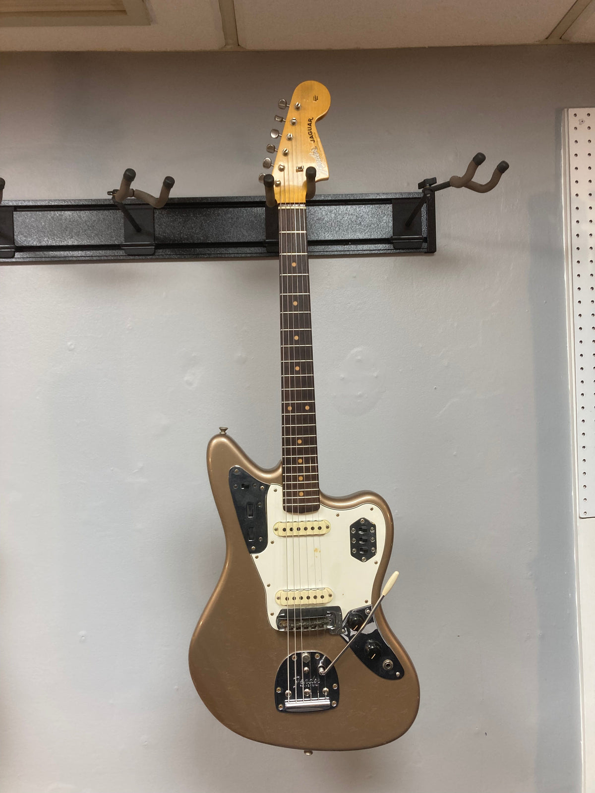 Fender Custom Shop Jaguar Journeyman electric guitar on a wall, showcasing its vintage design and craftsmanship.