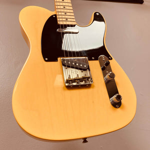 A close-up of a yellow Fender Custom Shop '51 Reissue Nocaster NOS 2006 electric guitar, featuring a black pickguard, metal bridge, and control knobs against a plain background.
