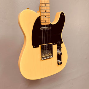 A cream Fender Custom Shop '51 Reissue Nocaster NOS 2006 electric guitar by Fender, featuring a black pickguard and chrome hardware, is mounted on a light gray wall.