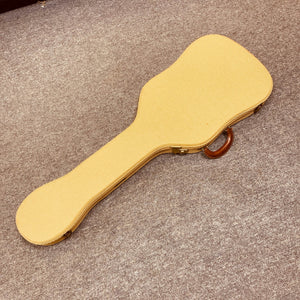 A tan Fender Custom Shop '51 Reissue Nocaster NOS 2006 guitar case with a brown handle rests closed on a beige carpeted floor.