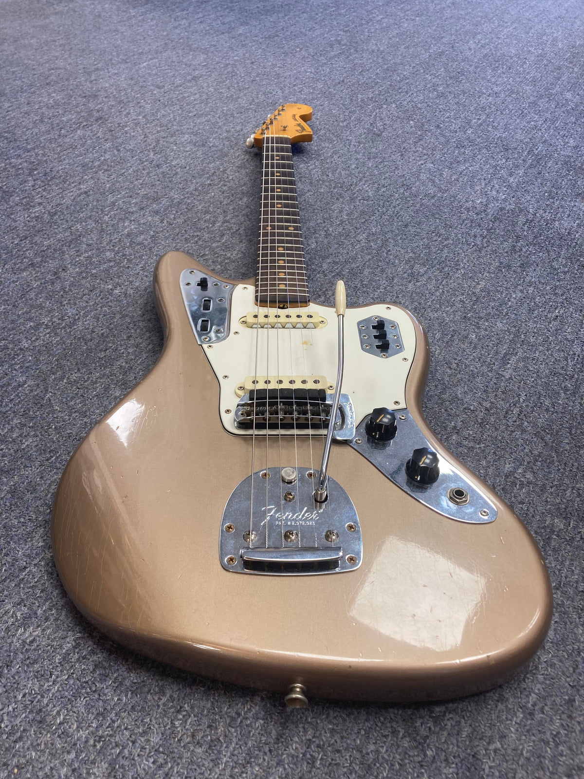 Fender Custom Shop Jaguar Journeyman electric guitar on a carpet, showcasing its strings and neck details.