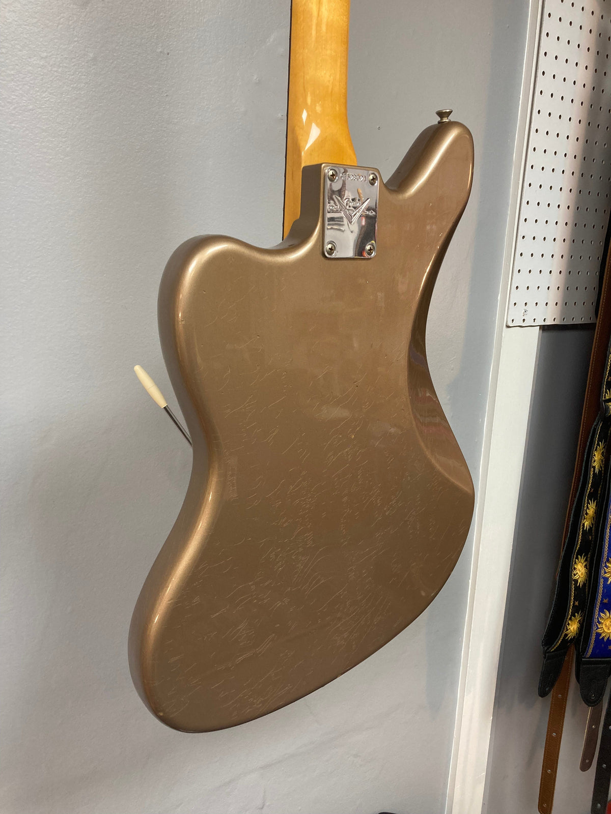 Fender Custom Shop Jaguar Journeyman electric guitar with custom relic finish, displayed on a wall.