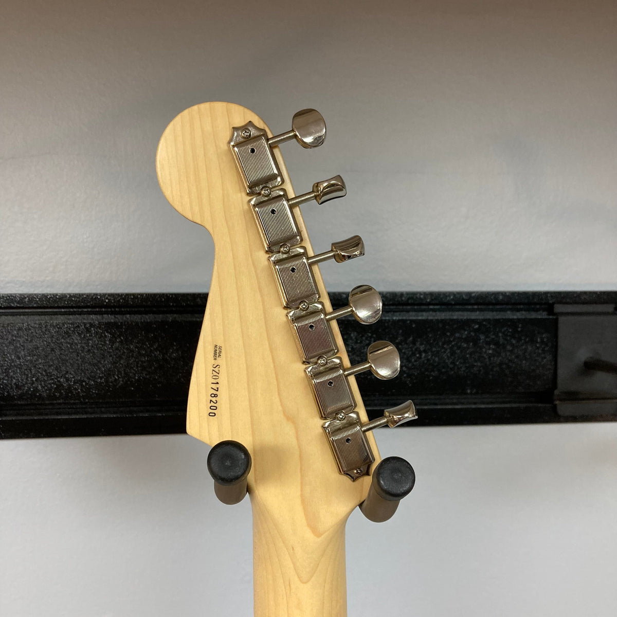 Fender Eric Clapton Artist Series Stratocaster USA 2001 with a close-up of its neck and tuning pegs, showcasing pristine condition. Includes original case.