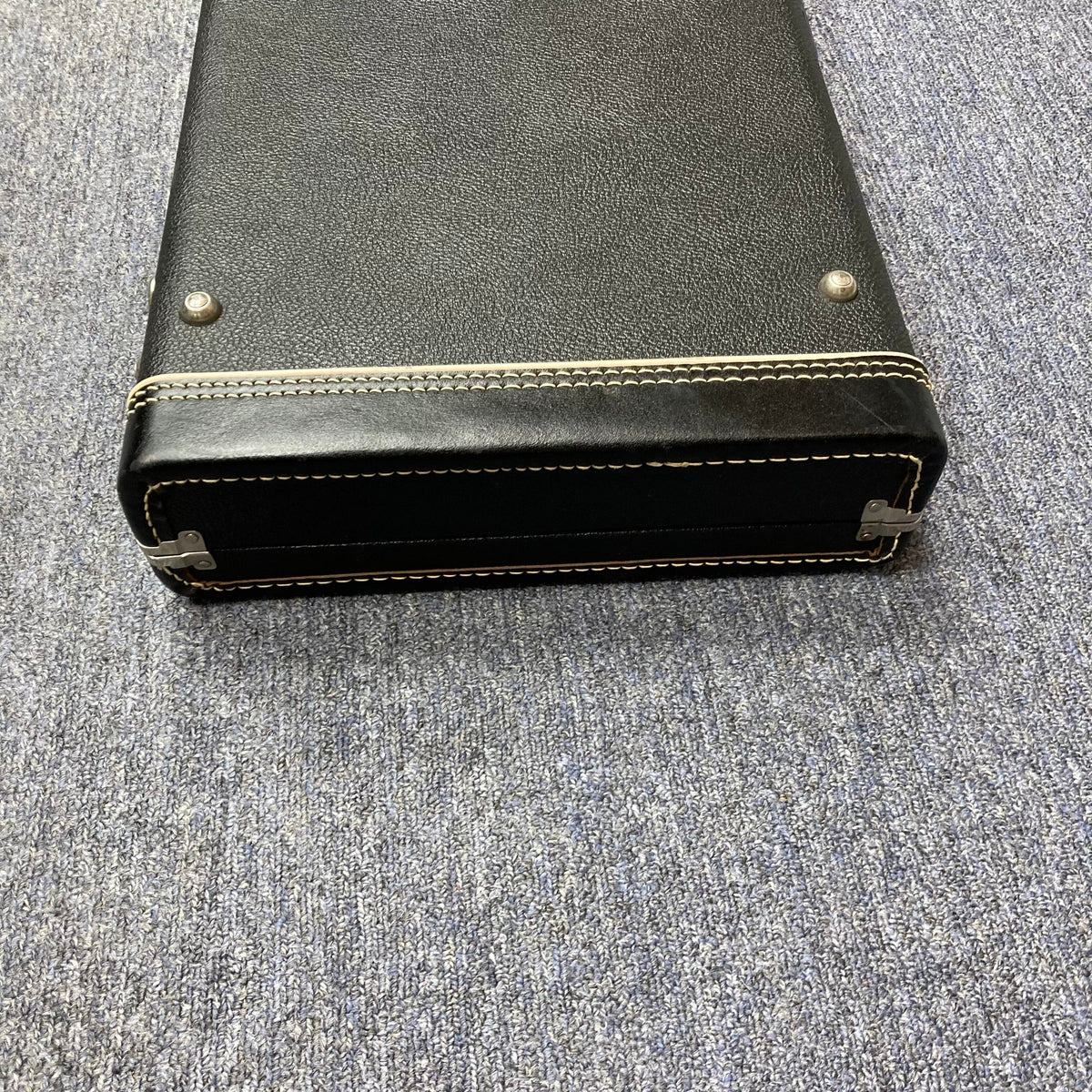 Vintage Fender Guitar Case, genuine from late &#39;60s to early &#39;70s, black leather with stitching, shown on carpet. Ideal for collectors and musicians.