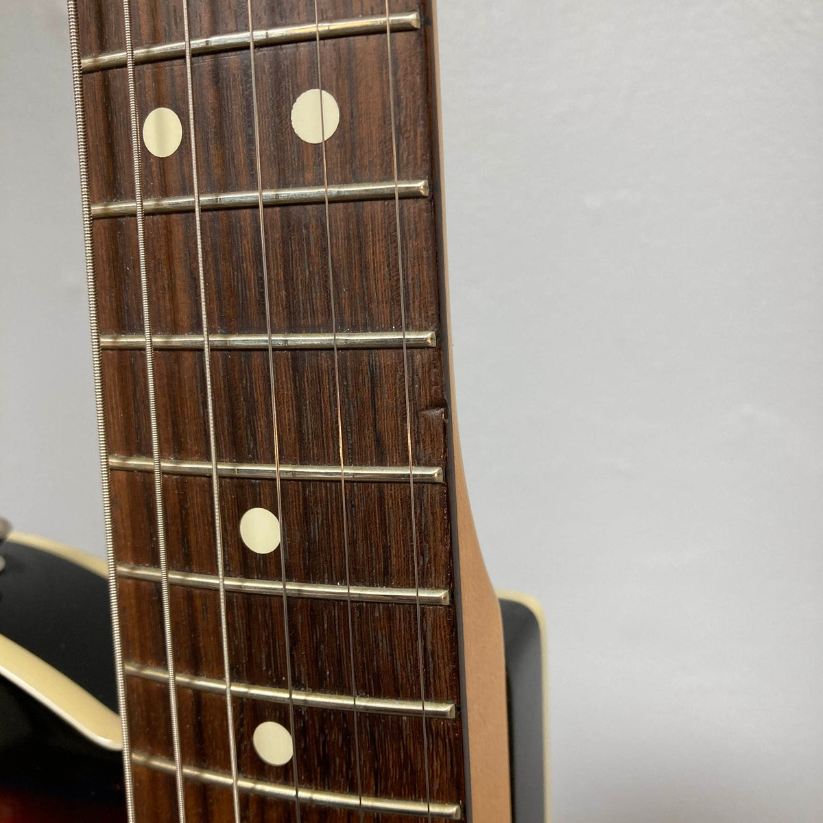 Close-up of a Fender Heritage '60s Telecaster Custom (Made in Japan, Sunburst) neck showing wood chipped along the fretboard edge near the fourth fret.