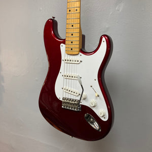 Fender Japan Stratocaster Candy Apple Red 2004 electric guitar with white knobs, close-up of the guitar bridge, includes original case.