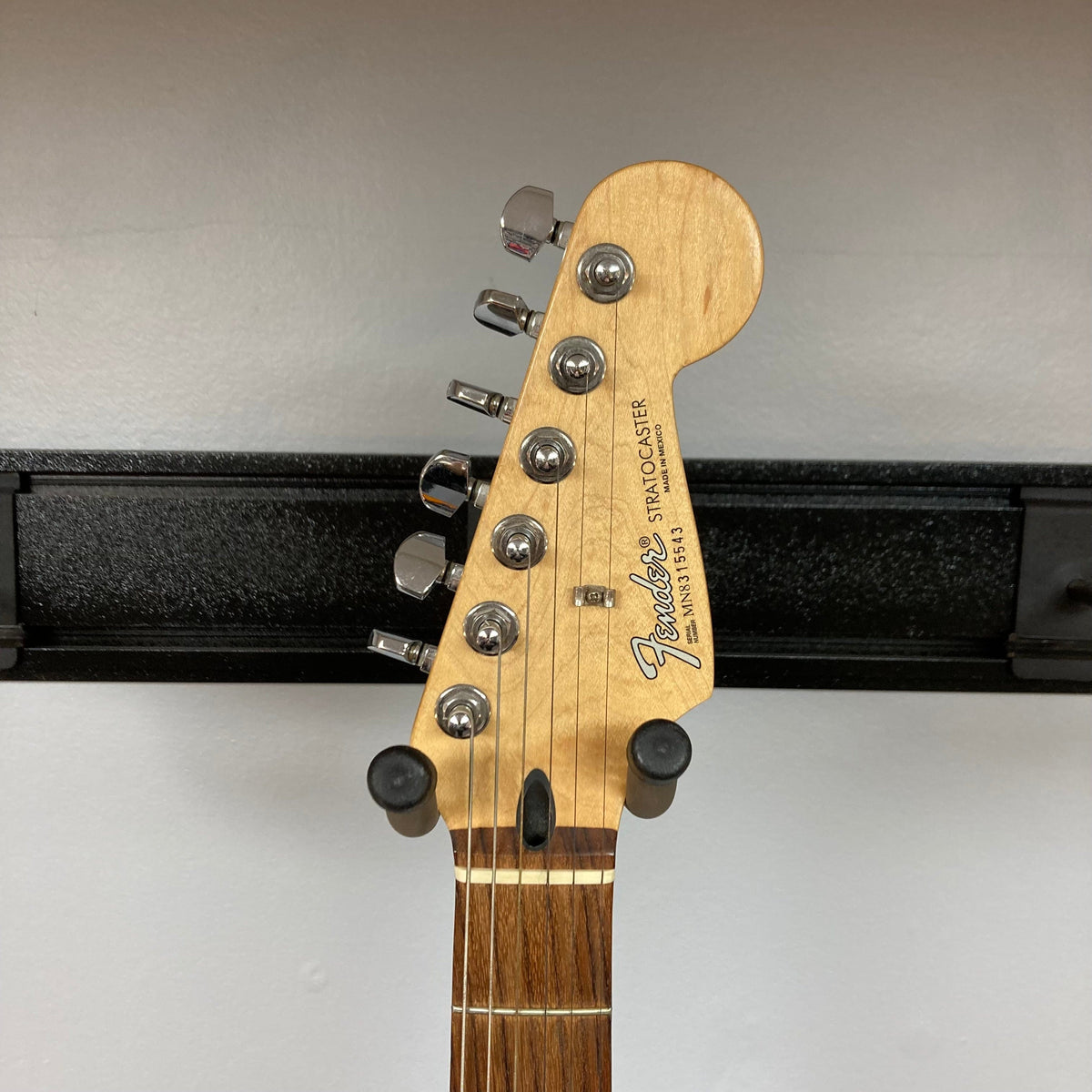 Fender MIM Stratocaster Blue 1998, close-up of headstock and body on a stand, highlighting versatile pickup configuration and well-used condition.