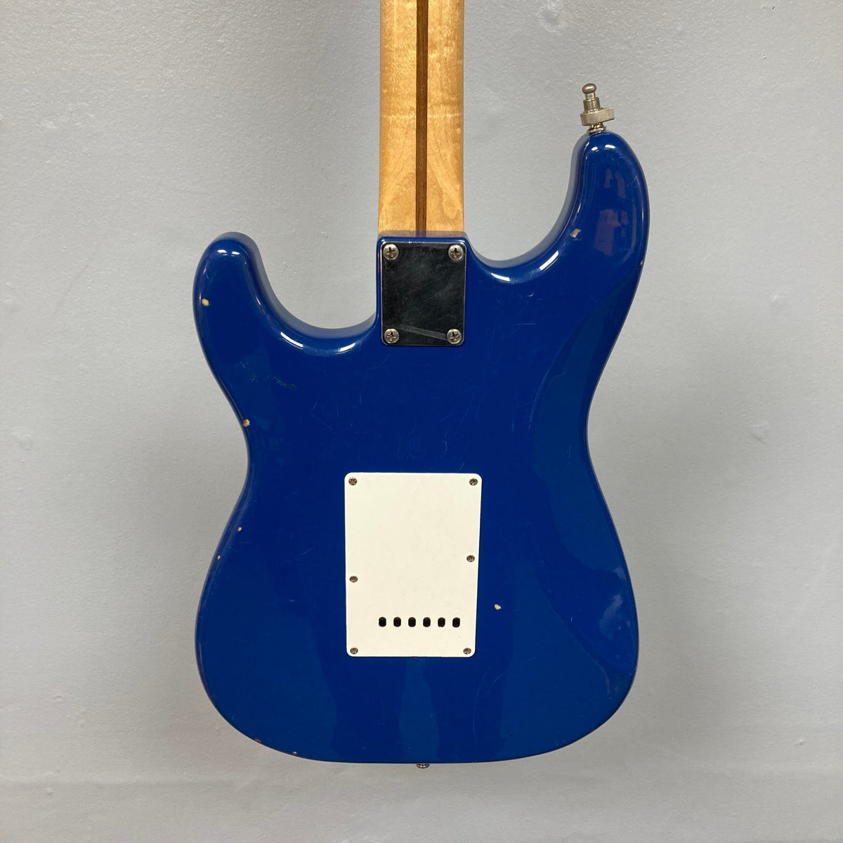 Fender MIM Stratocaster Blue 1998, electric guitar with white label on the back, featuring a humbucker bridge pickup, and well-used condition.