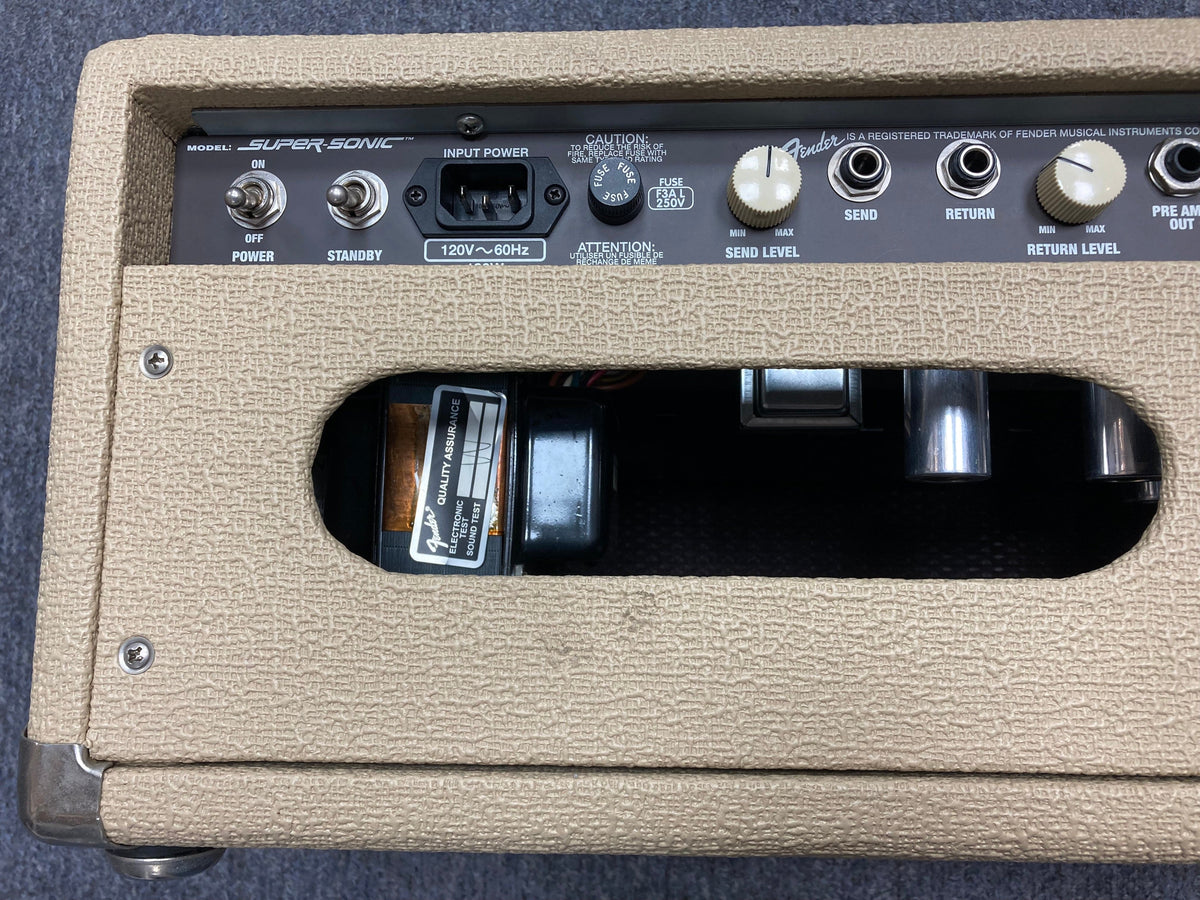 Close-up of a Fender Super Sonic 60-Watt Amp Head, showing control knobs and switches.