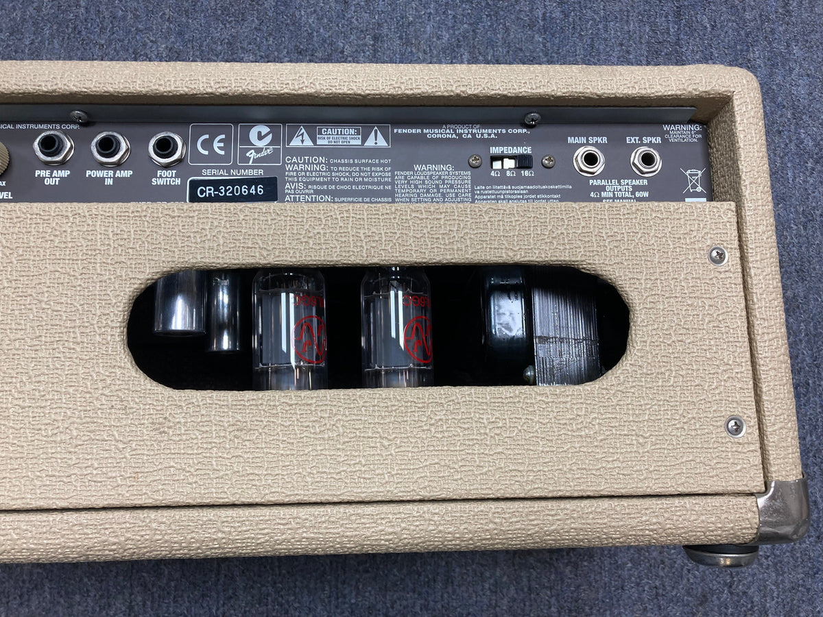 Close-up of a Fender Super Sonic 60-Watt Amp Head, showcasing its dual channels and control knobs.