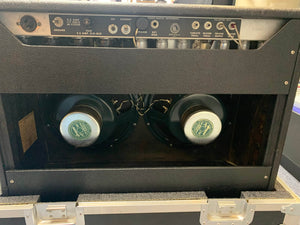 The back of a 1966 Fender Twin Reverb 2-Channel 85-Watt 2x12" Guitar Combo Amp is open, showing two large speakers and glowing vacuum tubes.