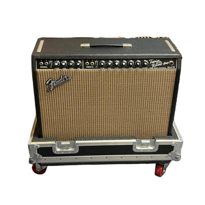 A 1966 Fender Twin Reverb 2-Channel 85-Watt 2x12" Guitar Combo Amp by Fender rests on a flight case, showcasing blackface styling, a black and silver control panel, woven grill cloth, and classic spring reverb.