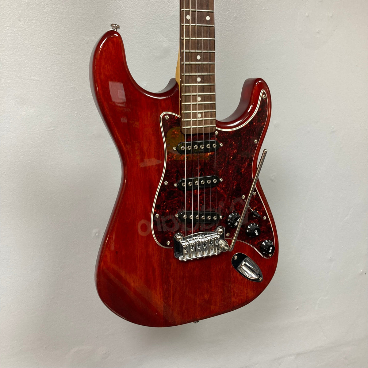 G&amp;L Tribute Series S-500 Irish Ale Used, red electric guitar with nato body, maple neck, and rosewood fingerboard, displayed on a wall.