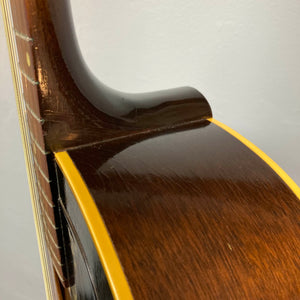 Close-up of the neck joint on a Gibson J-45 1957 Serial U-8664-1, showing its slope shoulder design, glossy wood finish, and yellow binding inspired by classic Gibson craftsmanship.