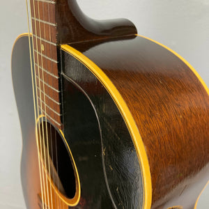 Close-up of a Gibson J-45 1957 (Serial U-8664-1) acoustic guitar, highlighting its wood grain, yellow binding, and glossy yet slightly worn body finish.