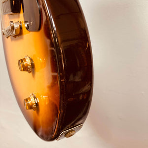 Close-up of a Gibson Les Paul Junior 1957 Sunburst electric guitar body by Gibson, featuring two control knobs, input jack, and minor side scratches against a plain background.