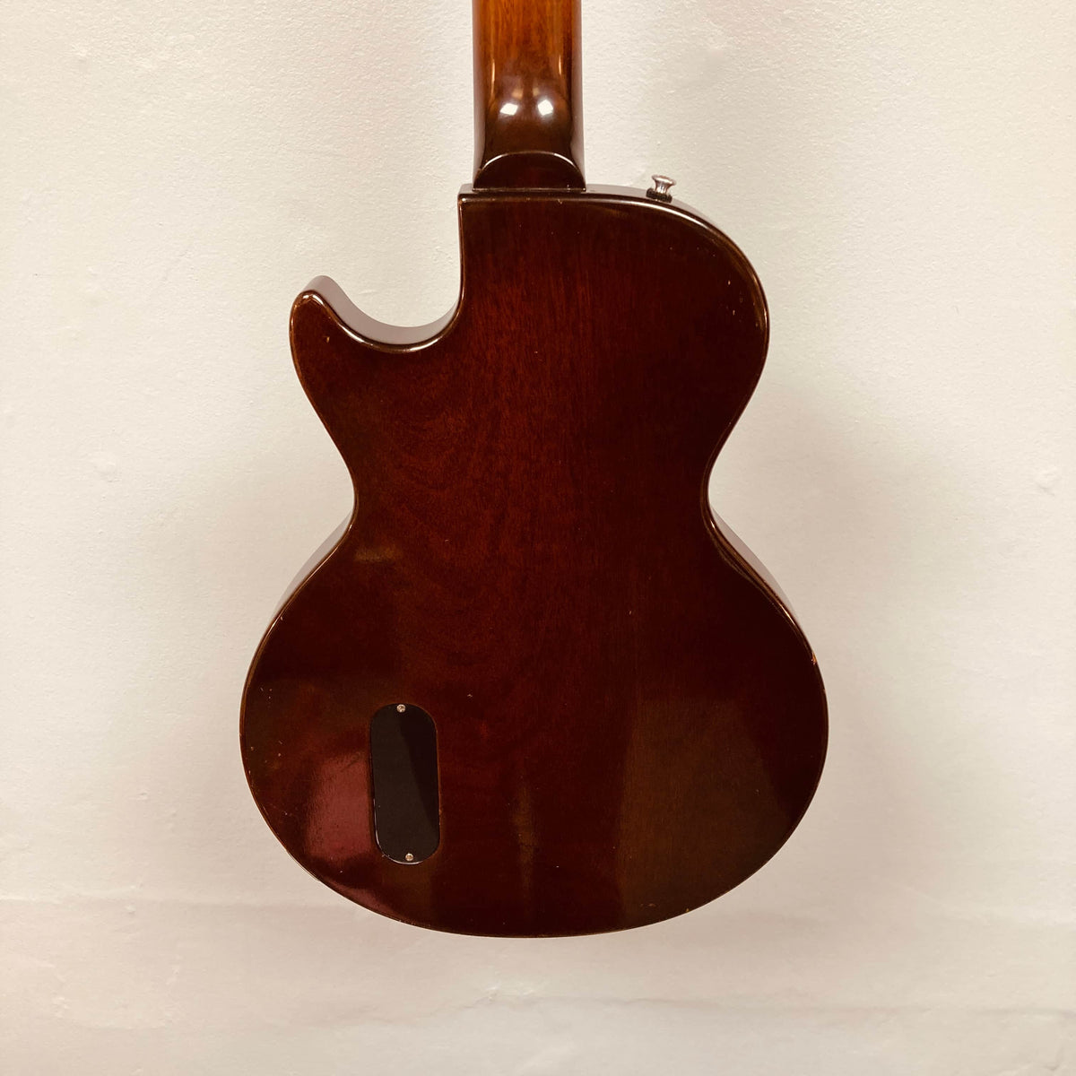 Rear view of a Gibson Les Paul Junior 1957 Sunburst electric guitar by Gibson, featuring a dark wood body with a single cutaway, displayed against a plain white background.