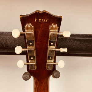 Close-up of the back of a Gibson Les Paul Junior 1957 Sunburst headstock by Gibson, showing six tuning pegs, white knobs, and stamped serial number “72738”—classic vintage electric guitar details.