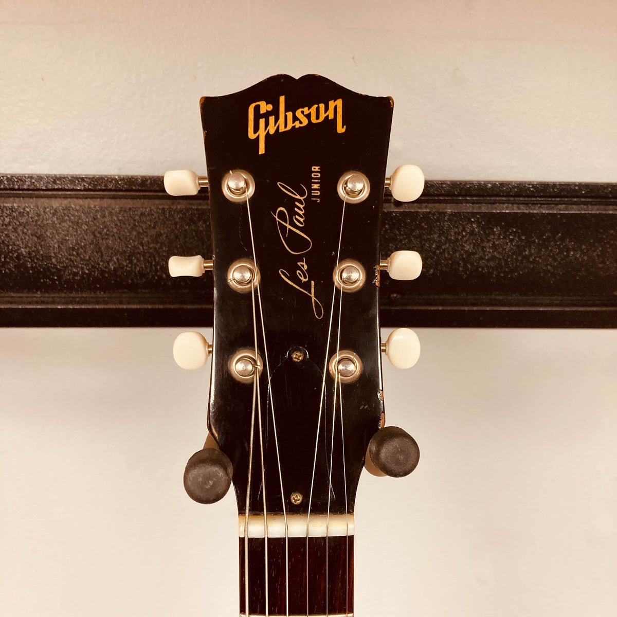 Close-up of a Gibson Les Paul Junior 1957 Sunburst headstock, showing tuning pegs and the Gibson logo against a neutral background.