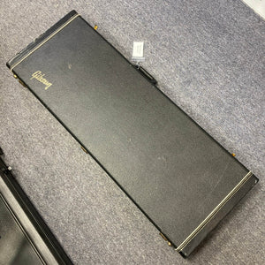 A black rectangular hard case with the Gibson logo, from Guitars on Main, holds a Gibson RD Artist 1977–1982 guitar and rests closed on a gray carpeted floor.