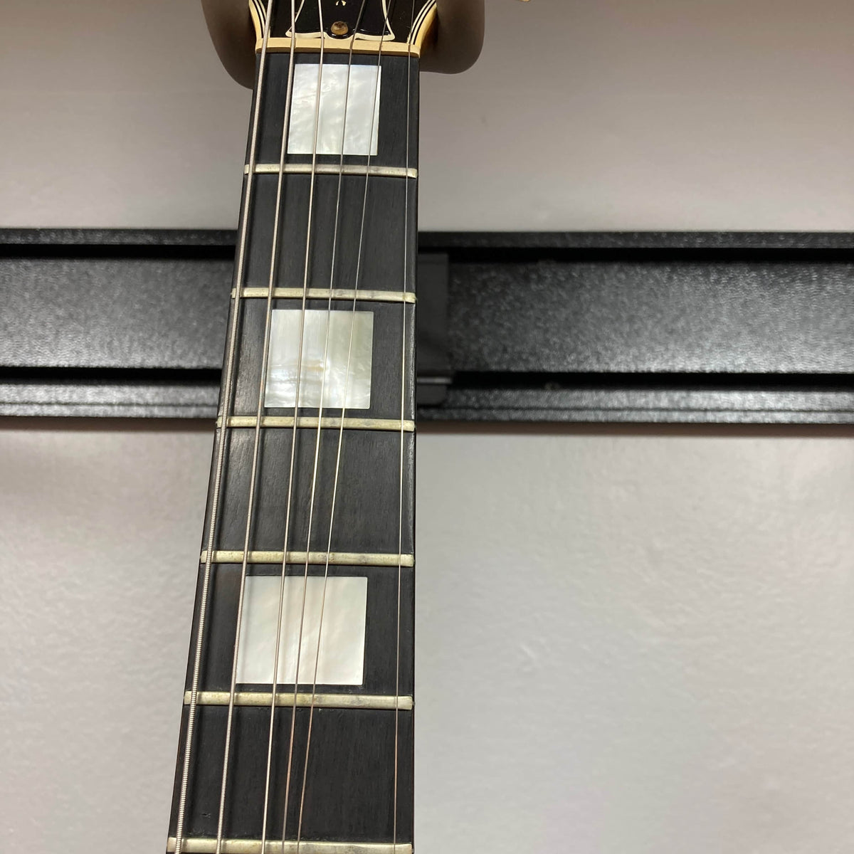 Close-up of a Gibson RD Artist 1977-1982 neck by Guitars on Main, showing rectangular mother-of-pearl inlays at the 5th, 7th, and 9th frets against a light background—an ideal collectible for vintage electric guitar fans.