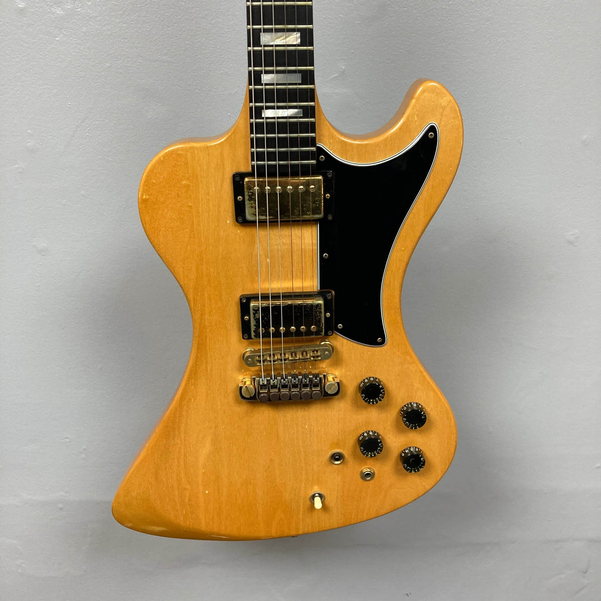 The Guitars on Main Gibson RD Artist 1977–1982 w/Case features a natural finish, distinctive angular body, black pickguard, dual humbuckers, four control knobs, and a toggle switch—shown against a plain gray background.