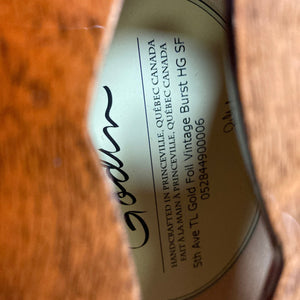 Close-up of the Godin 5th Ave TL Vintage Burst HG Gold Foil guitar label, showcasing its craftsmanship and unique tonal qualities.