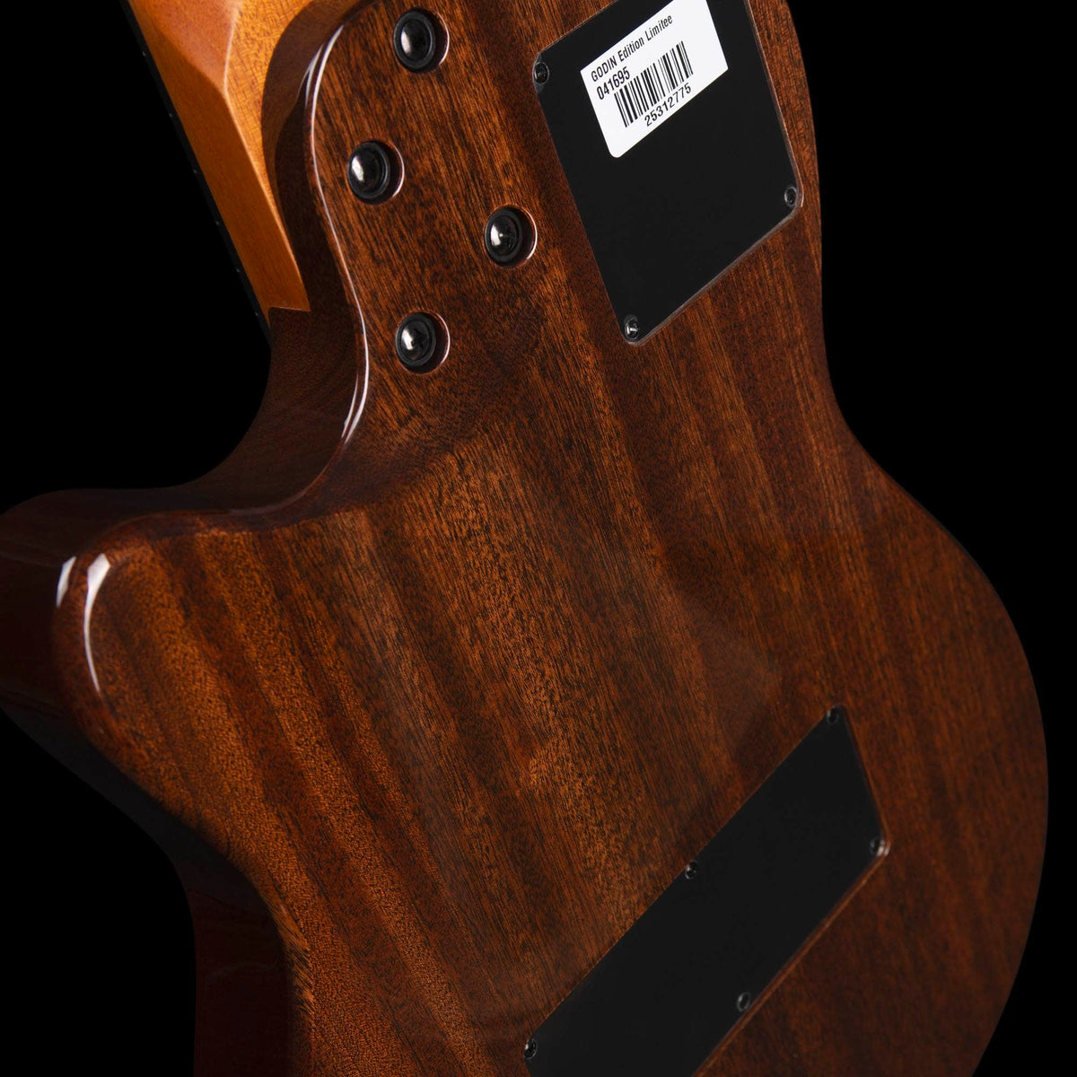 Back of a polished wooden Godin A6 Ultra Deluxe Natural w/Gigbag body, showing the neck joint with four bolts and a rectangular information sticker with a barcode.