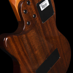 Back of a polished wooden Godin A6 Ultra Deluxe Natural w/Gigbag body, showing the neck joint with four bolts and a rectangular information sticker with a barcode.