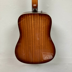 Back view of the Godin Century Maho Rustic Burst EQ SF dreadnought acoustic electric guitar by Godin, featuring a glossy brown wood finish, set against a plain light-colored wall.